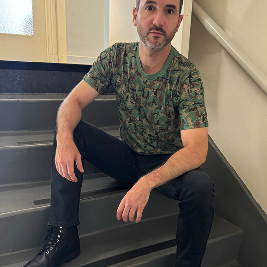 person sitting on steps wearing a Kama Sutra Camo Sexy NSFW T-shirt