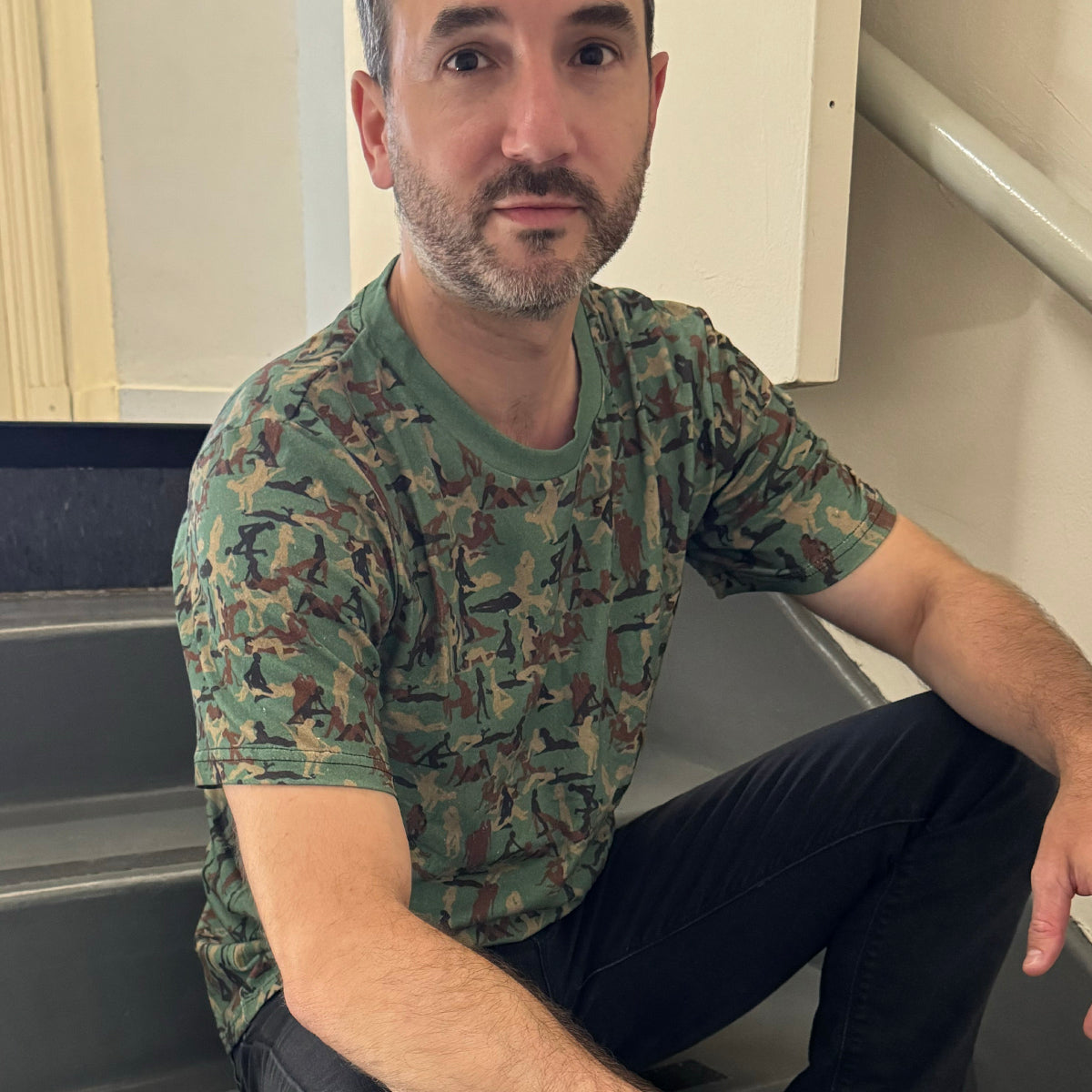 person sitting on steps wearing a Kama Sutra Camo Sexy NSFW T-shirt CLOSE UP