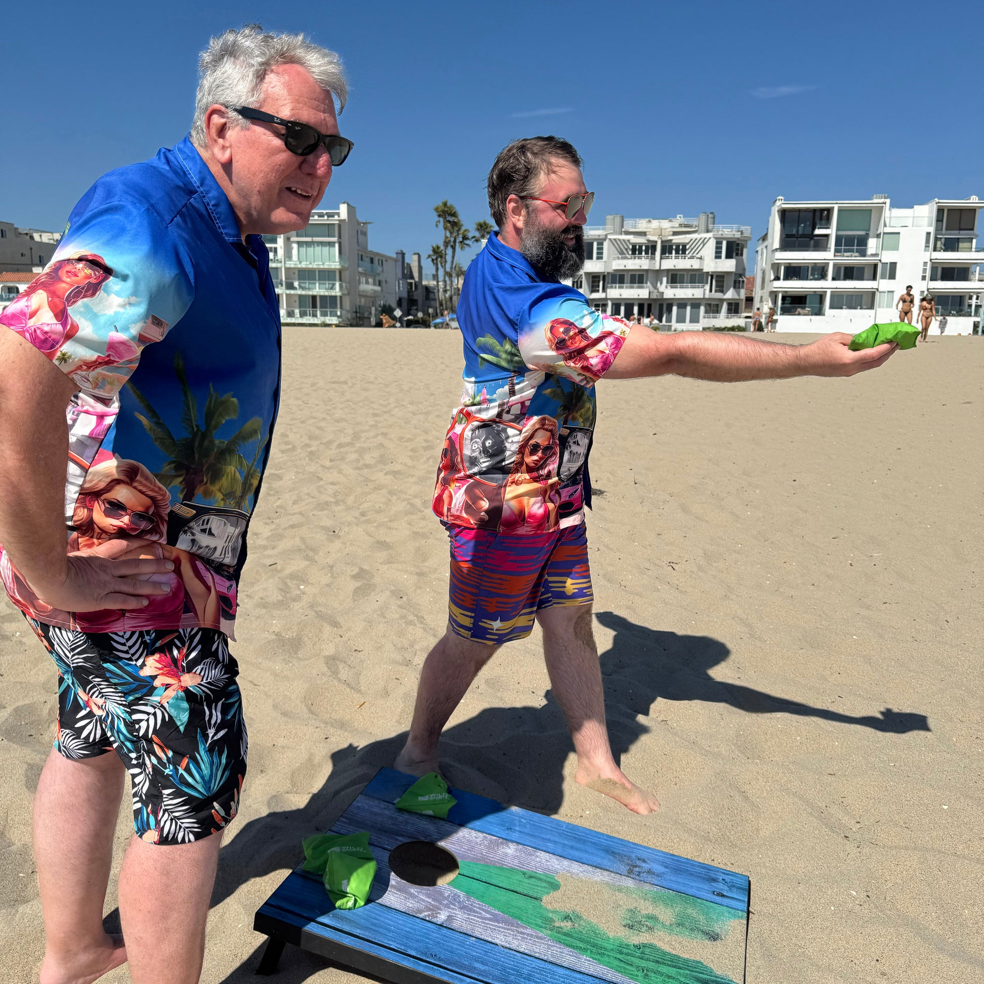 Two guys wearing They Live Miami-flavored Hawaiian style button down shirt at beach