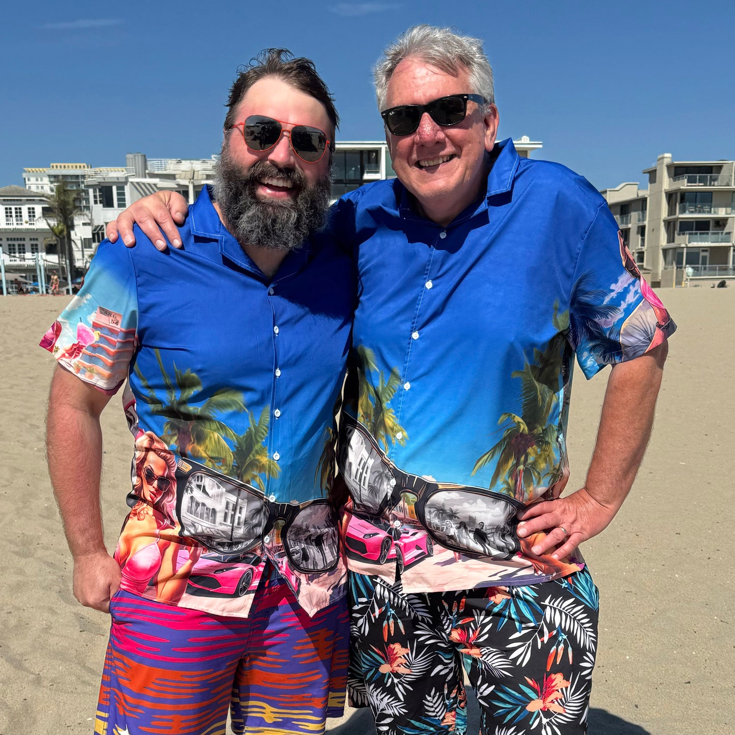 Two guys wearing They Live Miami-flavored Hawaiian style button down shirt at beach