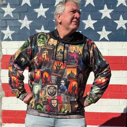 Man wearing a colorful hoodie with secret organization poster designs in front of an American flag mural.