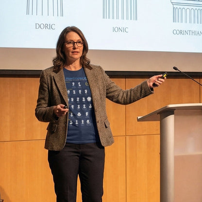 Woman giving a presentation on a stage wearing the guide to 21 Roman Emperors 