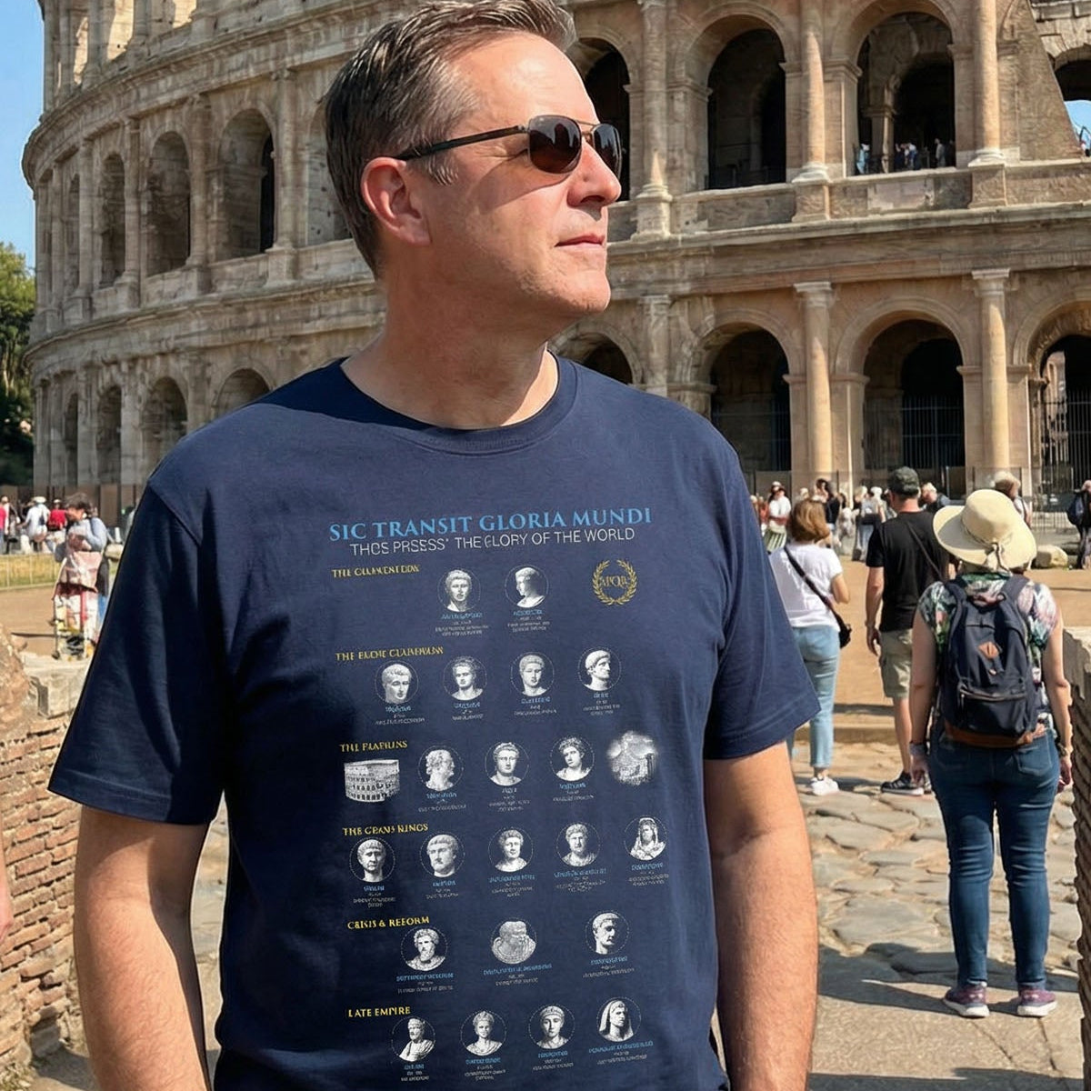 Man wearing a navy blue t-shirt with guide to 21 Roman Emperors graphic in front of the Colosseum.