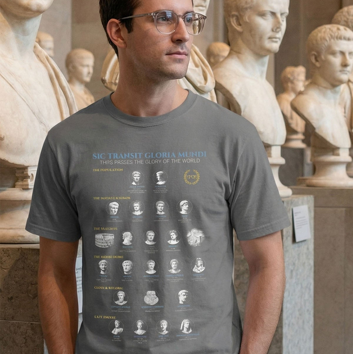 Man wearing a gray t-shirt with a graphic design in front of stone busts.
